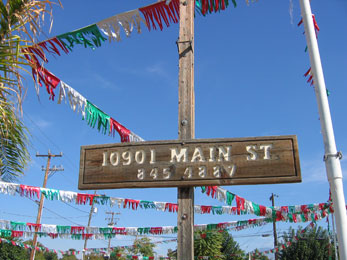 wooden mainstreet sign with colourful bunting against a bright blue sky